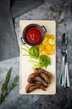 meat ribs with avocado, chips and ketchup on a white plate