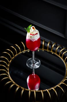 red cocktail with whipped cream instead of topping and mint leaves