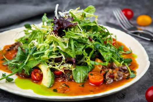 meat gravy with meat, cherry tomatoes and a bunch of greens on top