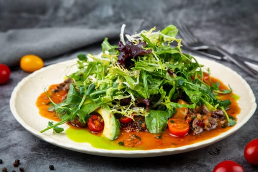 meat gravy with meat, cherry tomatoes and a bunch of greens on top