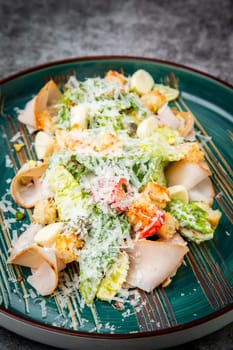 caesar salad with cheese on a blue plate. High quality photo