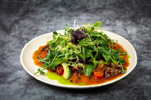 meat gravy with meat, cherry tomatoes and a bunch of greens on top