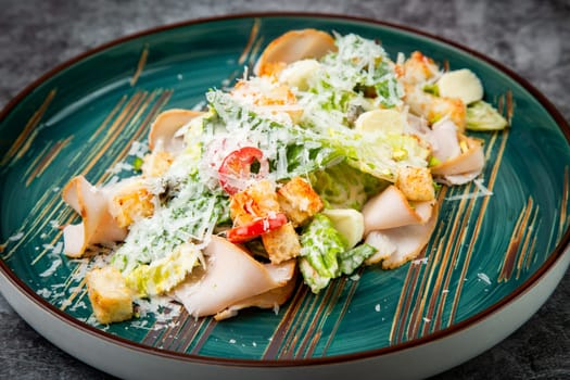 caesar salad with cheese on a blue plate. High quality photo