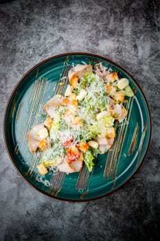 caesar salad with cheese on a blue plate. High quality photo