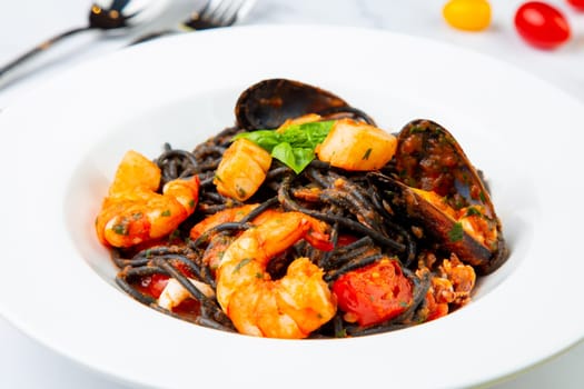 black noodles with mussels, shrimp, tomatoes and herbs