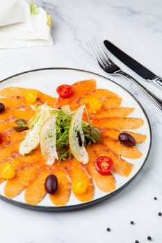 Sliced red fish slices with herbs, cherry tomatoes and white bread croutons. High quality photo