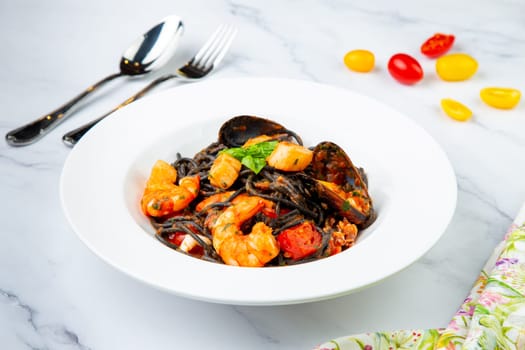 black noodles with mussels, shrimp, tomatoes and herbs
