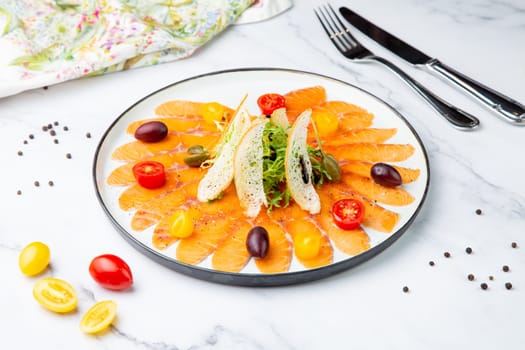 Sliced red fish slices with herbs, cherry tomatoes and white bread croutons. High quality photo