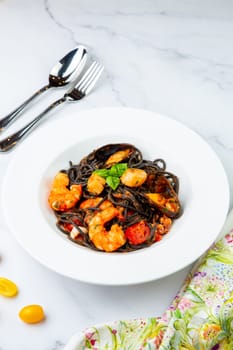 black noodles with mussels, shrimp, tomatoes and herbs