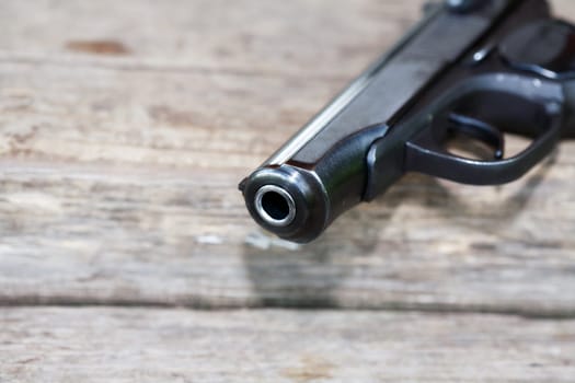 Handgun closeup on old wooden background