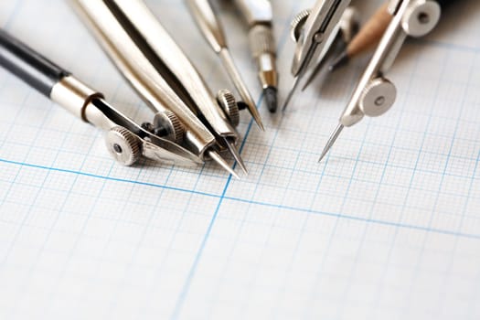 Set of old drawing tools on background with graph paper