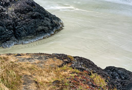 Rocks and sand on Pacific ocean beach near Tofino, British Columbia, Canada.