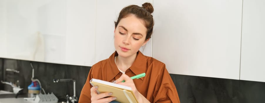 Portrait of woman drawing in notebook, writing down her thoughts on paper.