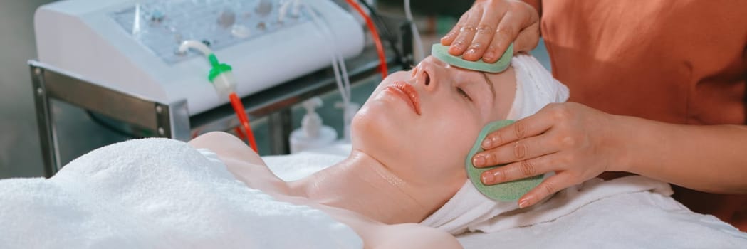 Attractive caucasian woman receive electrical facial treatment. Beautiful girl lies on spa bed while having medical treatment from professional doctor from medical spa center. Tranquility.