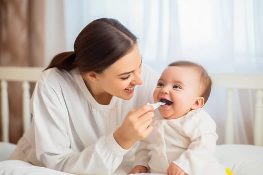 A happy mom feeds her baby from a spoon