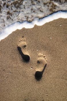 Photographic documentation footprints of people on gray sand 
