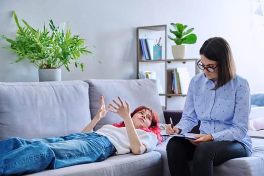 Session therapy of teenage student girl with counseling psychologist. Female teenager lying on couch talking about problem mental health. Adolescence psychology therapy psychotherapy professional help