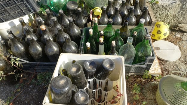 Ozieri, Sardinia, Italy. August 21 2021. Plastic boxes full of used and abandoned wine bottles in the countryside.