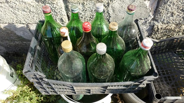 Ozieri, Sardinia, Italy. August 21 2021. Plastic boxes full of used and abandoned wine bottles in the countryside.