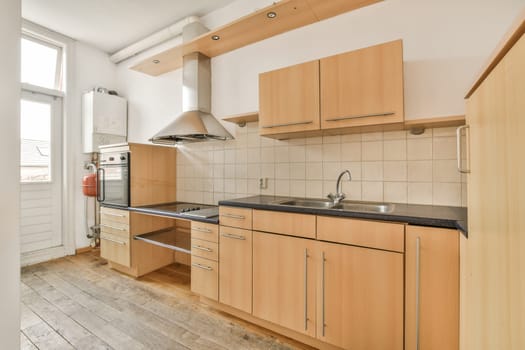 a kitchen with wood cabinets and black counter tops on the island in front of the sink is white tiled walls