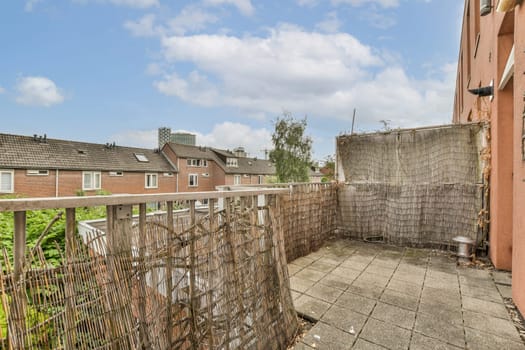 an outside area with a fence and some buildings in the background, taken from behind it is a blue sky