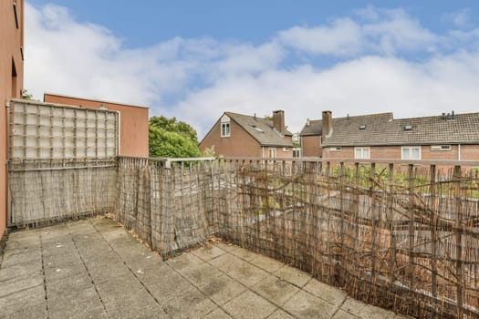 an outside area with fences and houses in the background on a cloudy day, as seen from behind it