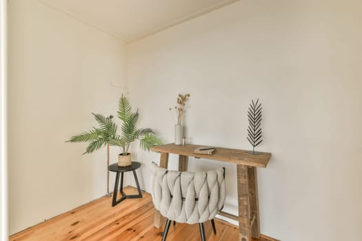 a living room with wood flooring and white walls, including a wooden table that has some plants on it