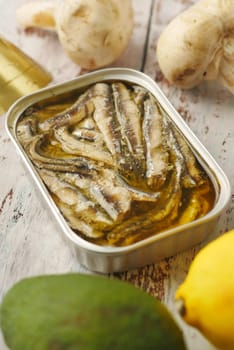 open tin of sardines on white tiles background