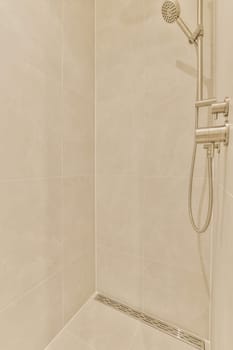 a shower in a bathroom with beige tile walls and white tiles on the wall, there is an open shower head