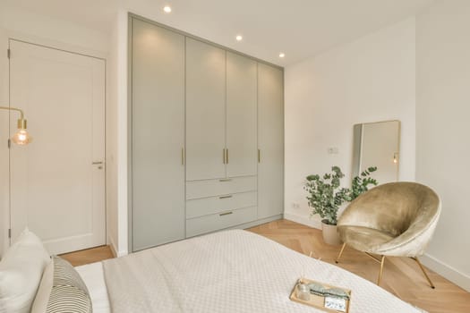 a bedroom with a bed, chair and mirror on the wall in front of the door to the other room