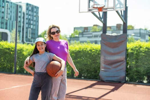 Mother and daughter playing basketball.