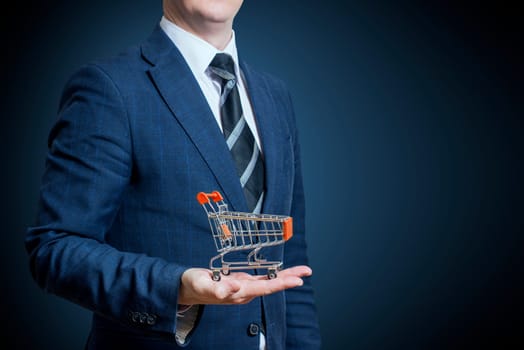Businessman holding a shopping cart on his hand