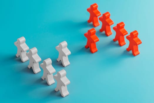 Two groups of wooden figures are standing in front of each other. Two groups of toy people in the discussion. Conflict of interest. Business competition. Candidates political debate.