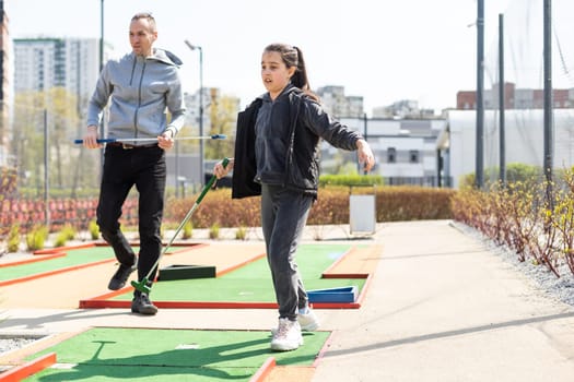 Family Time Playing Mini-Golf In The Summer.