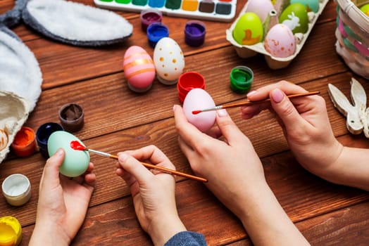 Mother and son are painting Easter eggs. Preparing decorations for Easter, creativity with children, traditional symbols. Preparing for Easter.