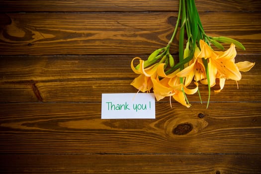 bouquet of beautiful yellow lilies on a dark wooden table