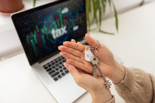 woman holding key with laptop and taxes.