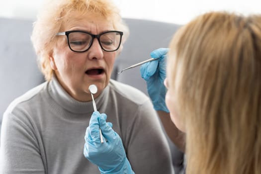 Close up portrait of elderly beautiful woman check up and having the consultation with dentist at the dental office