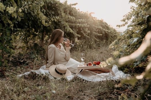 Picnic and wine tasting at sunset in the hills of Italy, Tuscany. Vineyards and open nature in the summer. Romantic dinner, fruit and wine.