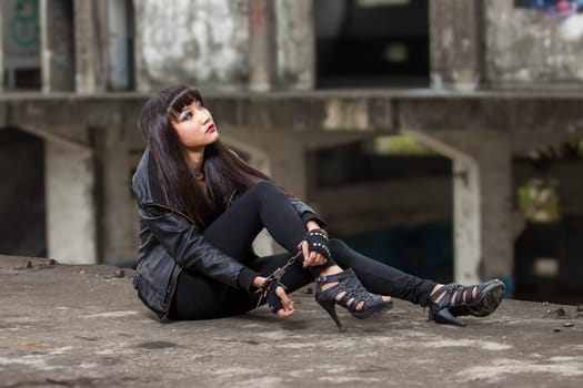 Asian American woman in emo goth clothing at an abandoned building