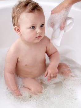 Baby, bubbles and bath or water cleaning for skin or hair wash for childhood development, hygiene or soap. Child, boy and tub for relax wellness or wet in home for play or cleansing, foam or sanitary.