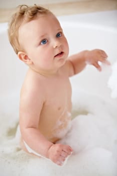 Baby, bubbles and bath or water cleaning for skin or hair wash for childhood development, hygiene or soap. Child, boy and tub for relax wellness or wet in home for play or cleansing, foam or sanitary.