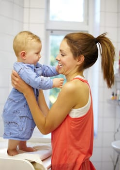 Mother, holding and baby for dressing in home on changing table for future, growth or development. Young woman, infant and playful in morning with smile of face for child, curiosity and motor skills.