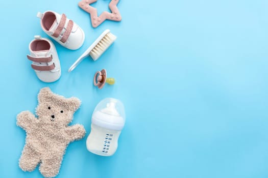 A collection of newborn accessories artistically arranged on a calming blue background, top view