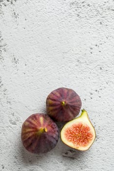View of whole and cut organic figs on stone table