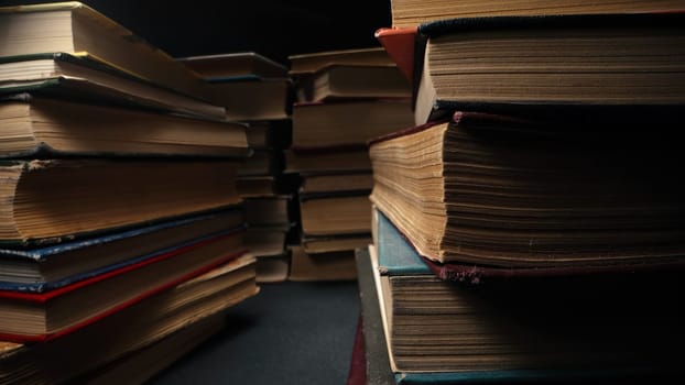 Library stack of old books, macro, camera between rows in antique shop. Bookstore in vintage style. Literature, knowledge, information concept. High quality