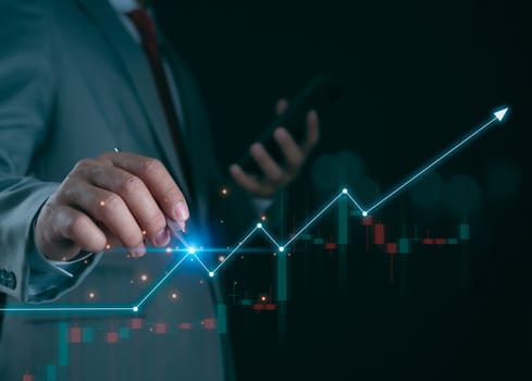 Business development concept for success and growth, Businessman taps a pen on indicator line to a graph for showing the future growth plans of his organization. Finance, management, plans, strategy