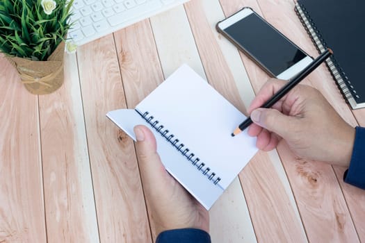 Businessman hands with pen writing notebook on office desk table. Copy space. Business concept.