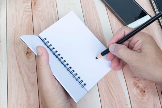 Businessman hands with pen writing notebook on office desk. Copy space. Business concept.