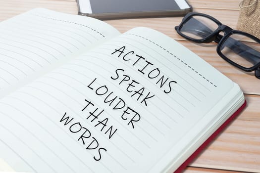 Actions speak louder than words text on notepad. Business mindset concept.